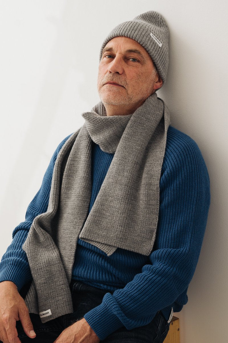 Mann trägt nachhaltigen SALZWASSER Schal in Hellgrau aus Merinowolle