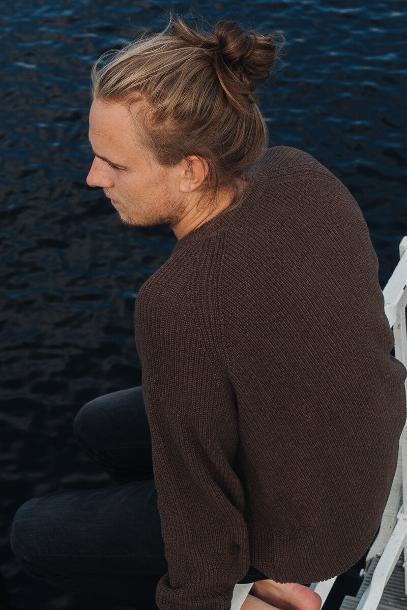 Mann trägt lockeren Strickpullover aus Bio-Baumwolle von SALZWASSER in Braun